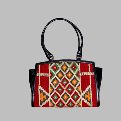 Elibelinde Kilim PU Leather Bag M size is Handcrafted in Old Cairo, Egypt, This bag is one of a kind  masterpiece, made from vintage fabrics and genuine leather to embody the essence of sustainable luxury.a gift to the world of Ancient craftsmanship meeting modern functionality. A statement of creativity, cultural awareness and limitless style.
