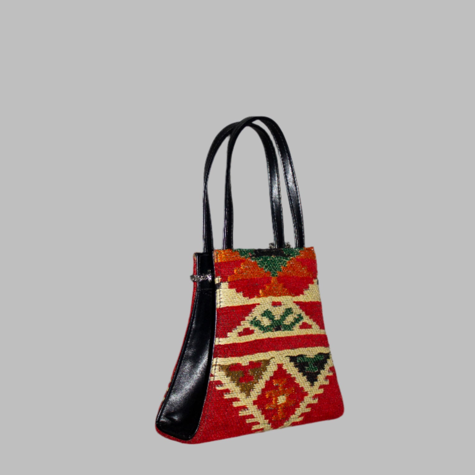 Elibelinde Weekend Kilim PU Leather Bag S size is Handcrafted in Old Cairo, Egypt, This bag is one of a kind  masterpiece, made from vintage fabrics and genuine leather to embody the essence of sustainable luxury.a gift to the world of Ancient craftsmanship meeting modern functionality. A statement of creativity, cultural awareness and limitless style.
