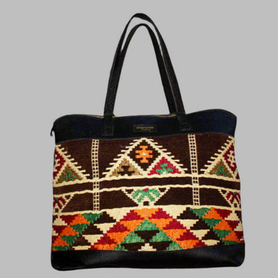 Weekend Kilim Genuine Leather Bag XL size is Handcrafted in Old Cairo, Egypt, This bag is one of a kind  masterpiece, made from vintage fabrics and genuine leather to embody the essence of sustainable luxury.a gift to the world of Ancient craftsmanship meeting modern functionality. A statement of creativity, cultural awareness and limitless style.