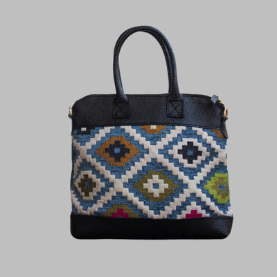 Weekend Kilim Genuine Leather Bag is Handcrafted in Old Cairo, Egypt, This bag is one of a kind  masterpiece, made from vintage fabrics and genuine leather to embody the essence of sustainable luxury.a gift to the world of Ancient craftsmanship meeting modern functionality. A statement of creativity, cultural awareness and limitless style.