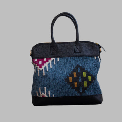 Weekend Kilim Genuine Leather Bag is Handcrafted in Old Cairo, Egypt, This bag is one of a kind  masterpiece, made from vintage fabrics and genuine leather to embody the essence of sustainable luxury.a gift to the world of Ancient craftsmanship meeting modern functionality. A statement of creativity, cultural awareness and limitless style.