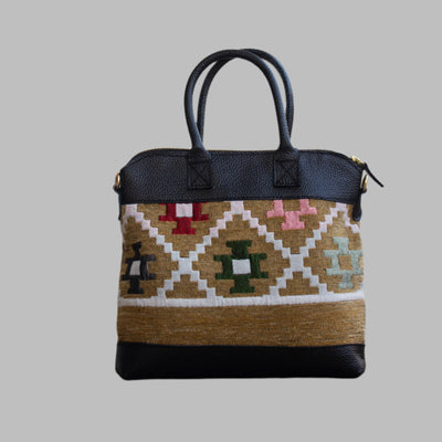 Weekend Kilim Genuine Leather Bag is Handcrafted in Old Cairo, Egypt, This bag is one of a kind  masterpiece, made from vintage fabrics and genuine leather to embody the essence of sustainable luxury.a gift to the world of Ancient craftsmanship meeting modern functionality. A statement of creativity, cultural awareness and limitless style.