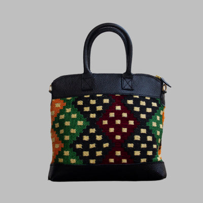 Weekend Kilim Genuine Leather Bag is Handcrafted in Old Cairo, Egypt, This bag is one of a kind  masterpiece, made from vintage fabrics and genuine leather to embody the essence of sustainable luxury.a gift to the world of Ancient craftsmanship meeting modern functionality. A statement of creativity, cultural awareness and limitless style.