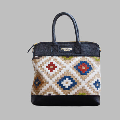Weekend Kilim Genuine Leather Bag is Handcrafted in Old Cairo, Egypt, This bag is one of a kind  masterpiece, made from vintage fabrics and genuine leather to embody the essence of sustainable luxury.a gift to the world of Ancient craftsmanship meeting modern functionality. A statement of creativity, cultural awareness and limitless style.