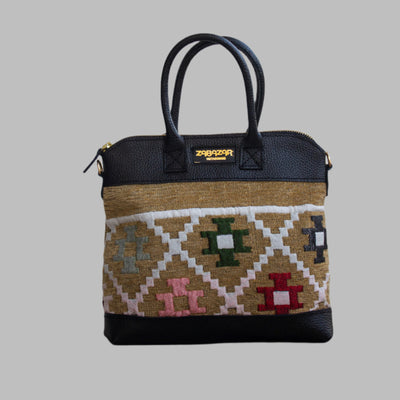 Weekend Kilim Genuine Leather Bag is Handcrafted in Old Cairo, Egypt, This bag is one of a kind  masterpiece, made from vintage fabrics and genuine leather to embody the essence of sustainable luxury.a gift to the world of Ancient craftsmanship meeting modern functionality. A statement of creativity, cultural awareness and limitless style.