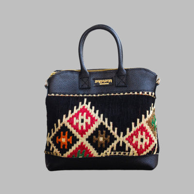 Weekend Kilim Genuine Leather Bag is Handcrafted in Old Cairo, Egypt, This bag is one of a kind  masterpiece, made from vintage fabrics and genuine leather to embody the essence of sustainable luxury.a gift to the world of Ancient craftsmanship meeting modern functionality. A statement of creativity, cultural awareness and limitless style.