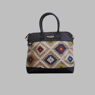 Weekend Kilim Genuine Leather Bag is Handcrafted in Old Cairo, Egypt, This bag is one of a kind  masterpiece, made from vintage fabrics and genuine leather to embody the essence of sustainable luxury.a gift to the world of Ancient craftsmanship meeting modern functionality. A statement of creativity, cultural awareness and limitless style.