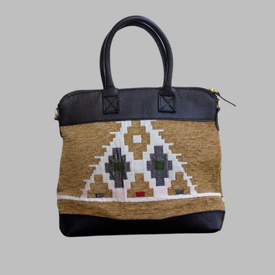 Weekend Kilim Genuine Leather Bag is Handcrafted in Old Cairo, Egypt, This bag is one of a kind  masterpiece, made from vintage fabrics and genuine leather to embody the essence of sustainable luxury.a gift to the world of Ancient craftsmanship meeting modern functionality. A statement of creativity, cultural awareness and limitless style.