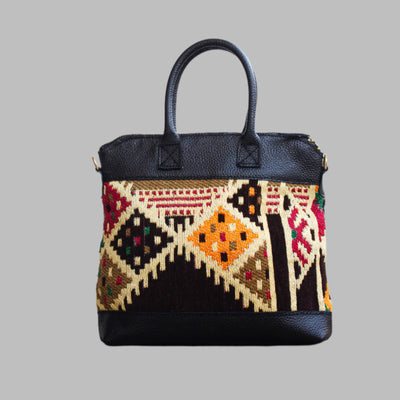 Weekend Kilim Genuine Leather Bag is Handcrafted in Old Cairo, Egypt, This bag is one of a kind  masterpiece, made from vintage fabrics and genuine leather to embody the essence of sustainable luxury.a gift to the world of Ancient craftsmanship meeting modern functionality. A statement of creativity, cultural awareness and limitless style.