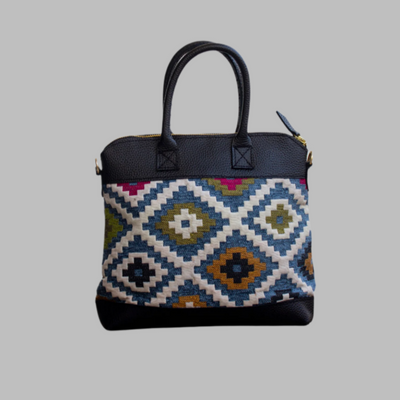 Weekend Kilim Genuine Leather Bag is Handcrafted in Old Cairo, Egypt, This bag is one of a kind  masterpiece, made from vintage fabrics and genuine leather to embody the essence of sustainable luxury.a gift to the world of Ancient craftsmanship meeting modern functionality. A statement of creativity, cultural awareness and limitless style.