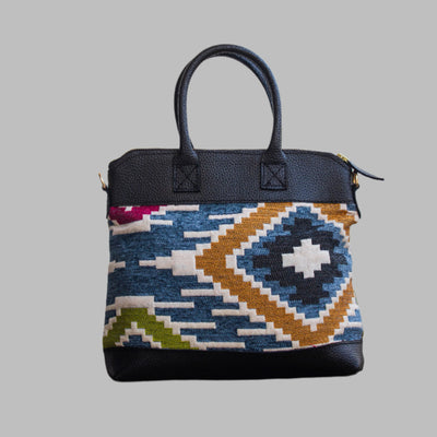 Weekend Kilim Genuine Leather Bag is Handcrafted in Old Cairo, Egypt, This bag is one of a kind  masterpiece, made from vintage fabrics and genuine leather to embody the essence of sustainable luxury.a gift to the world of Ancient craftsmanship meeting modern functionality. A statement of creativity, cultural awareness and limitless style.
