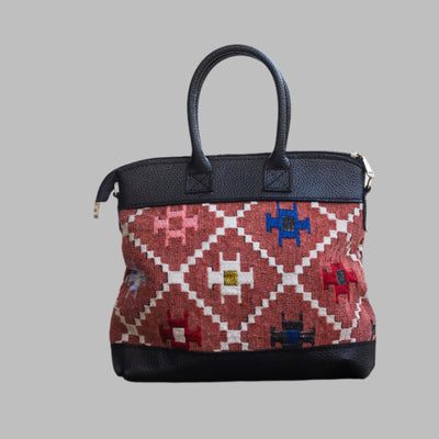 Weekend Kilim Genuine Leather Bag is Handcrafted in Old Cairo, Egypt, This bag is one of a kind  masterpiece, made from vintage fabrics and genuine leather to embody the essence of sustainable luxury.a gift to the world of Ancient craftsmanship meeting modern functionality. A statement of creativity, cultural awareness and limitless style.