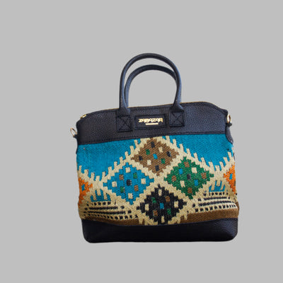 Weekend Kilim Genuine Leather Bag is Handcrafted in Old Cairo, Egypt, This bag is one of a kind  masterpiece, made from vintage fabrics and genuine leather to embody the essence of sustainable luxury.a gift to the world of Ancient craftsmanship meeting modern functionality. A statement of creativity, cultural awareness and limitless style.