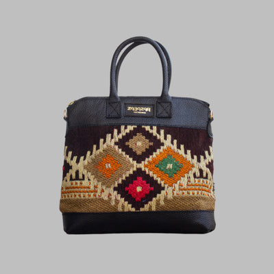 Weekend Kilim Genuine Leather Bag is Handcrafted in Old Cairo, Egypt, This bag is one of a kind  masterpiece, made from vintage fabrics and genuine leather to embody the essence of sustainable luxury.a gift to the world of Ancient craftsmanship meeting modern functionality. A statement of creativity, cultural awareness and limitless style.