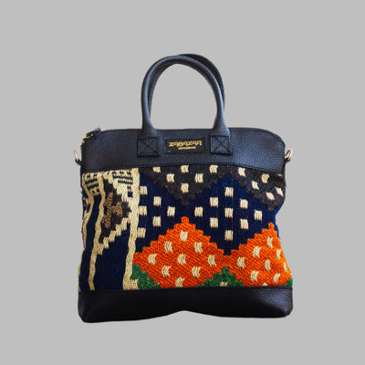 Weekend Kilim Genuine Leather Bag is Handcrafted in Old Cairo, Egypt, This bag is one of a kind  masterpiece, made from vintage fabrics and genuine leather to embody the essence of sustainable luxury.a gift to the world of Ancient craftsmanship meeting modern functionality. A statement of creativity, cultural awareness and limitless style.